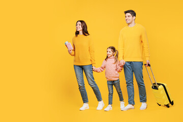 Wall Mural - Traveler parent mom dad with child kid girl wearing casual clothes hold bag passport ticket isolated on plain yellow background Tourist travel abroad in free time rest getaway Air flight trip concept