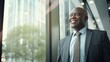 © Krtola  - African senior business man looking at the window