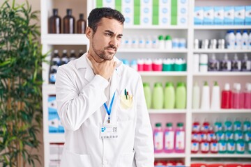 Canvas Print - Handsome hispanic man working at pharmacy drugstore touching painful neck, sore throat for flu, clod and infection