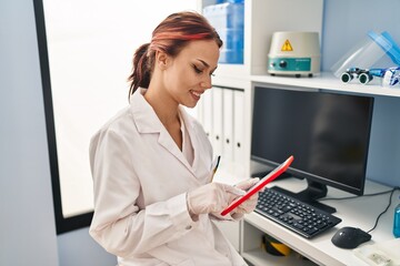 Sticker - Young caucasian woman scientist smiling confident using touchpad at laboratory