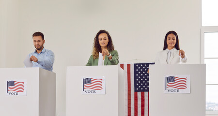 Wall Mural - Portrait of American citizens standing in a row at polling station and putting their ballots paper in voting booth. Happy people voters voting at vote center with usa flags on election day.