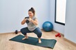 © Krakenimages.com - Young beautiful plus size woman using kettlebell training legs exercise at sport center