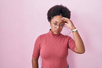 Poster - Beautiful african woman with curly hair standing over pink background worried and stressed about a problem with hand on forehead, nervous and anxious for crisis