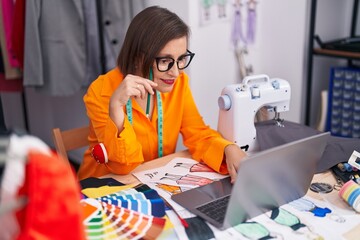 Poster - Middle age woman tailor smiling confident using laptop at tailor shop