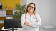 © Krakenimages.com - Middle age hispanic woman doctor standing with serious expression and arms crossed gesture at the clinic