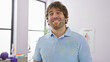 © Krakenimages.com - Smiling bearded man in clinic wearing polo, radiating positivity and well-being in healthcare setting.