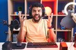 Hispanic man with beard playing video games with headphones celebrating mad and crazy for success with arms raised and closed eyes screaming excited. winner concept