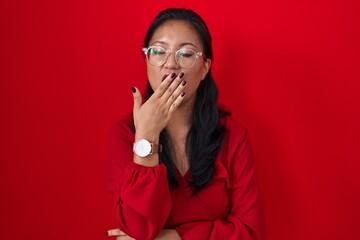 Canvas Print - Asian young woman standing over red background bored yawning tired covering mouth with hand. restless and sleepiness.