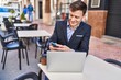 © Krakenimages.com - Young man business worker using laptop and smartphone at coffee shop terrace
