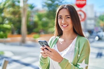 Sticker - Young beautiful hispanic woman smiling confident using smartphone at street