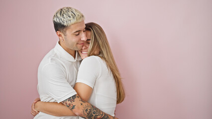 Wall Mural - Beautiful couple smiling confident hugging each other over isolated pink background