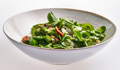 Wall Mural - Fresh spinach salad with bacon, walnuts, and vinaigrette in a white bowl on a clean background.