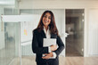 © Flamingo Images - Smiling businesswoman standing at the entrance to an office boardroom