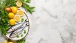 Sardines, lemon and salt on white plate on marble kitchen table, mideterranian cuisine on background with copy space. Fresh lemon and greenery are placed near the bowl