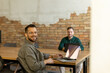© BGStock72 - Collaboration in Motion, Professionals Working Together in a Modern Brick-Walled Office