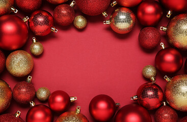 Wall Mural - Frame of beautiful Christmas balls on red background, top view. Space for text