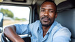 © MP Studio - Confident man with a beard smiling at the camera while sitting in the driver's seat of a vehicle, with his hands on the steering wheel.