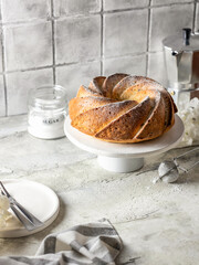 Homemade bundt cake in composition for morning cozy breakfast. Gray tile kitchen background