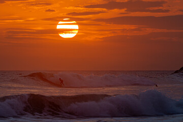 Surfing at sunset on the beach