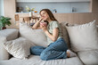 © DimaBerlin - Happy merry middle-aged European woman sitting on comfortable sofa with eyes closed, dreaming, thinking of pleasant things, drinking hot tea, coffee, cocoa, smelling aroma, relaxing in cozy atmosphere