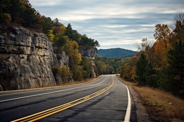 Wall Mural -  a view of a road with a cliff in the background and trees on both sides of the road and a cliff on the other side of the road.