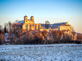 Wall Mural - Tyniec near Krakow, Poland. Benedictine abbey and monastery on the rocky cliff at Vistula River in winter in sunset light