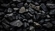 a high-resolution image displaying a variety of black stones with different textures and shapes, creating a natural, monochromatic background
