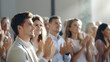 © red_orange_stock - A group of cheerful people clapping and celebrating during an event, expressing positivity and appreciation.