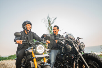 Wall Mural - asian riders talking at each other while sitting on motorcycle