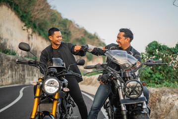 Canvas Print - asian riders sitting on motorbike with fist bump gesture