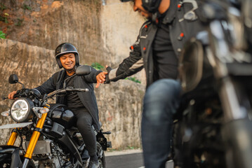 Canvas Print - indonesian man riding motorbike with hand shake gesture