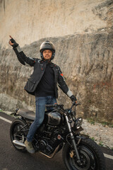 Sticker - asian man standing while riding motorcycle with open arm gesture