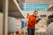 © Odua Images - Female supervisor counts furniture products on a shelf while checking with a tablet at a furniture store