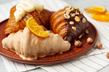 Wall Mural - Glazed croissants on clay plate on table