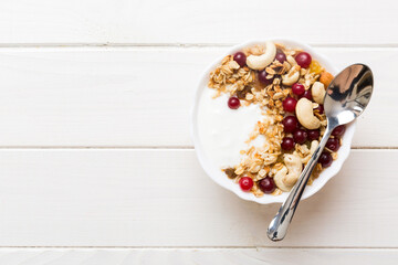 Wall Mural - Healthy breakfast food with granola, yogurt, fruits and nuts. Dessert parfait with dried fruits for breakfast