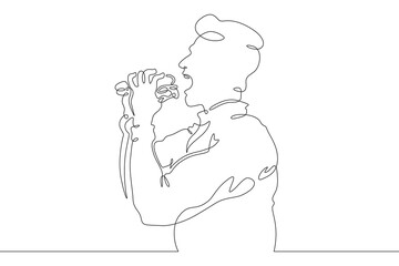 Wall Mural - A man eats street food. Fast food. A man holds food in his hands.One continuous line drawing. Linear. Hand drawn, white background. One line