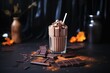 chocolate milkshake beside scattered cocoa powder and chocolate bar