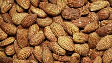 Wall Mural - top view flat lay pile of peeled raw almond nut seed texture food background footage rotate