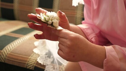 Wall Mural - The bride looks at the bouquet while holding it in her hands. Preparation for the wedding.