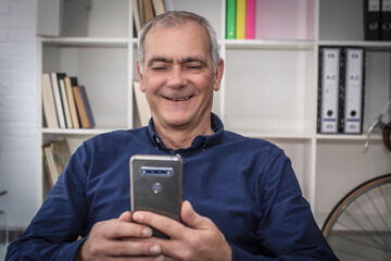 Wall Mural - mature man using mobile phone at his workplace