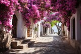 Fototapeta  -  a cobblestone street lined with pink flowers on either side of the building and steps leading up to the door.