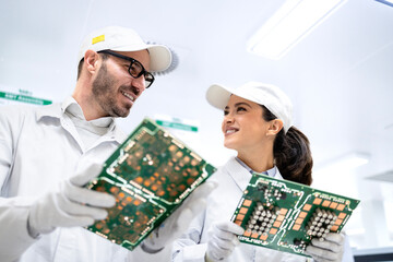 Wall Mural - Engineering technologist holding printed circuit boards and developing electronics components.