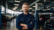 © Virtual Art Studio - Confident mechanic with arms crossed standing in a modern auto repair shop.