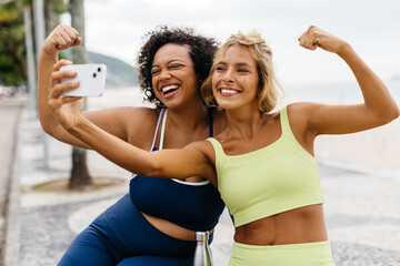 Wall Mural - Friends taking a selfie in sportswear, celebrating a successful beach workout