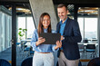© Westend61 - Happy businesswoman and businessman discussing over tablet PC