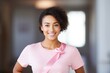 Smiling mixed race woman in pink T-shirt with pink ribbon, Breast Cancer Day