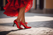 A girl in a red dress and shoes dances on the street. 