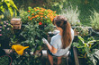 © Westend61 - Woman holding trowel and doing gardening in balcony