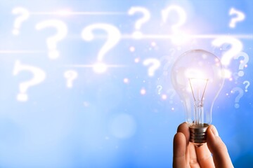 Poster - Businessman holding classic light bulb with question marks