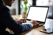 © FutureStock - Mockup cropped image of businessman's hands using laptop with blank white screen on wooden table in office.